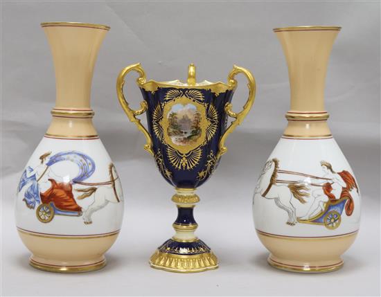 A Coalport three-handled pedestal vase and a pair of baluster vases
